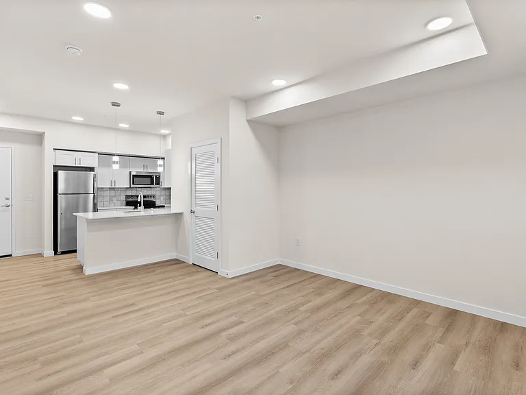 Spacious open-concept layout with modern kitchen finishes, stainless-steel appliances, and warm wood-style flooring. Spacious open-concept layout with modern kitchen finishes, stainless-steel appliances, and warm wood-style flooring.