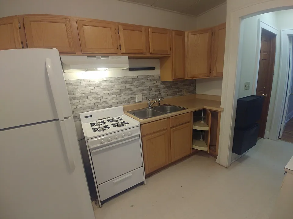 Kitchen featuring gas stove and newer refrigerator