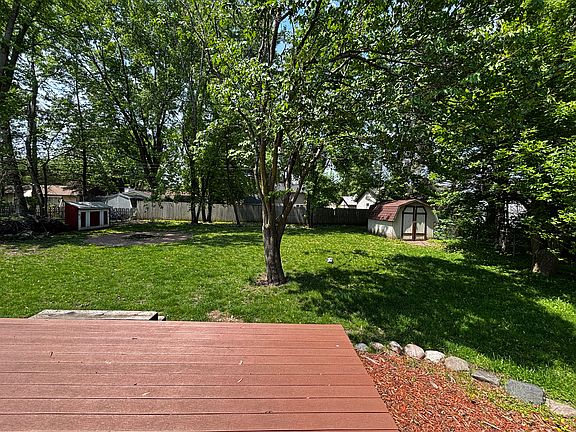 Back view of the house with a fire pit and shed