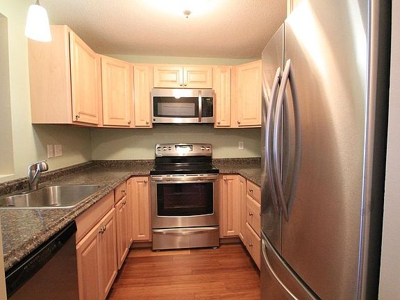 Kitchen with stainless steel appliances and trash/recycle pu