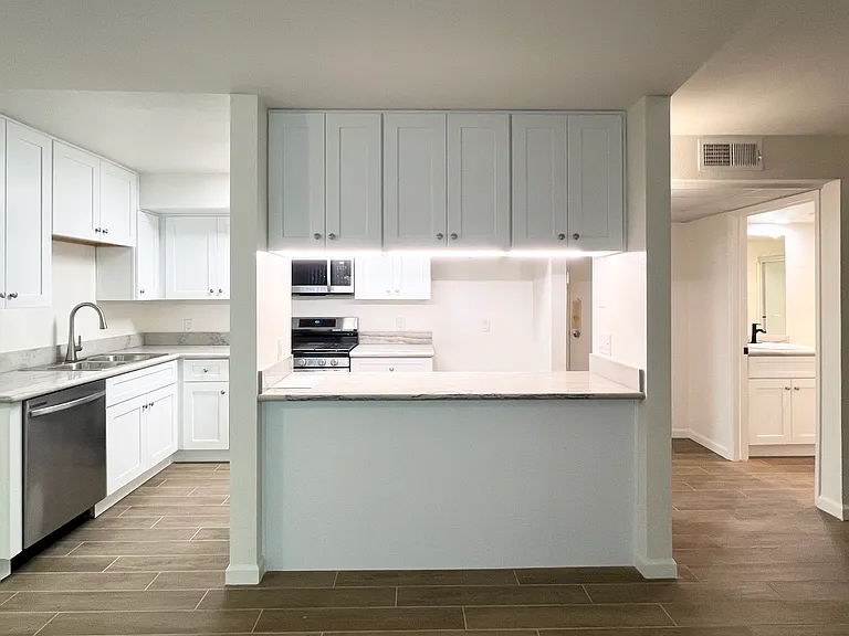 Kitchen Counter Island w/ overhead cabinets accessible on both sides & tile flooring