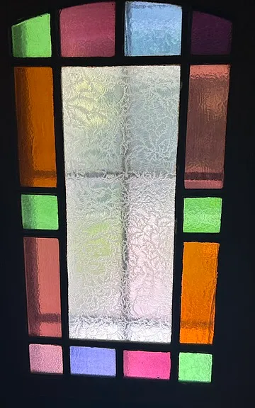 Vintage craftsmanship throughout, including a stained glass window in the front door
