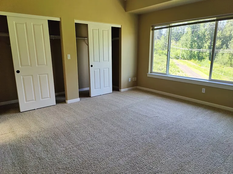 Master Bedroom with large picture window and shows the large bedroom closets.