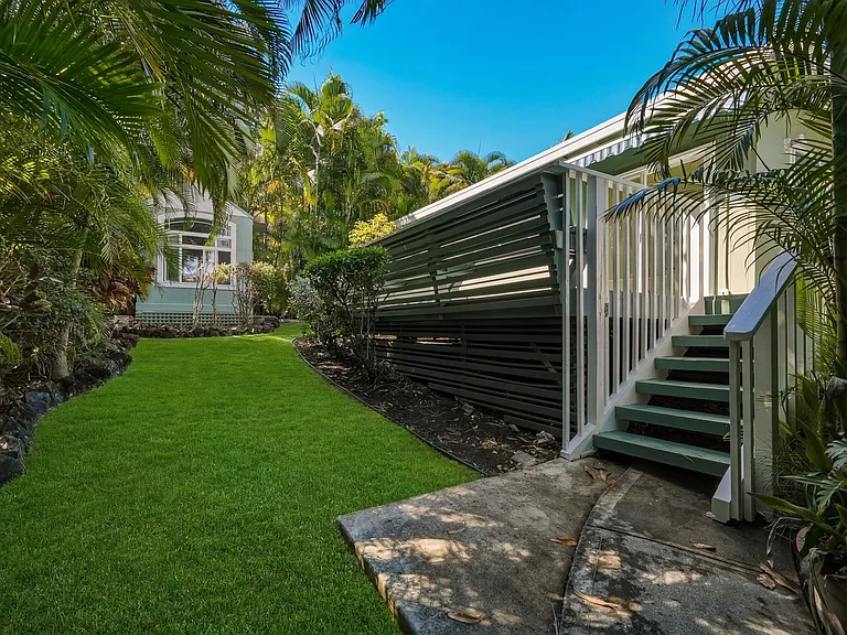 Up the steps to the detached cottage with a yard and lots of tropical landscaping- the storage shed in the back is for your use also.