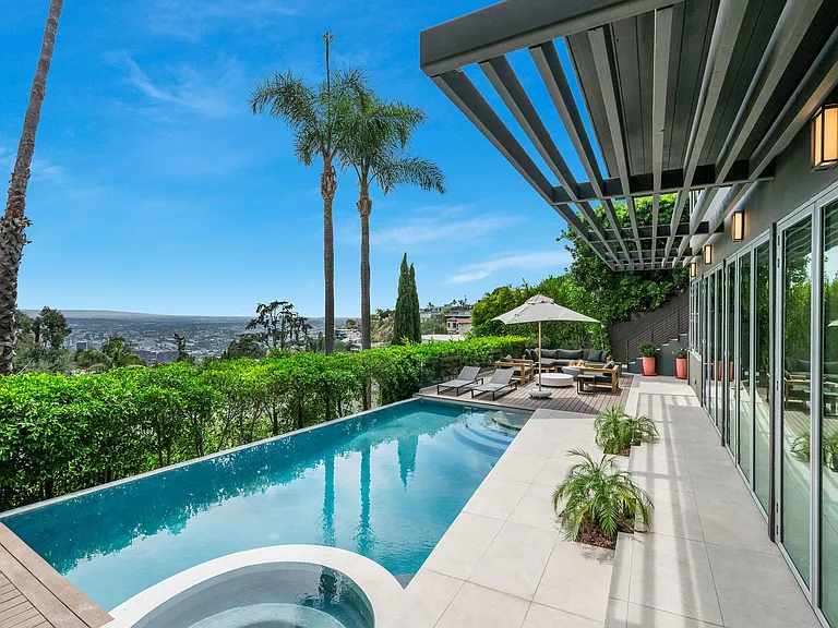 Outdoor area with pool, outdoor seating, indoor-outdoor fun room connecting the pool to the inside of the home.