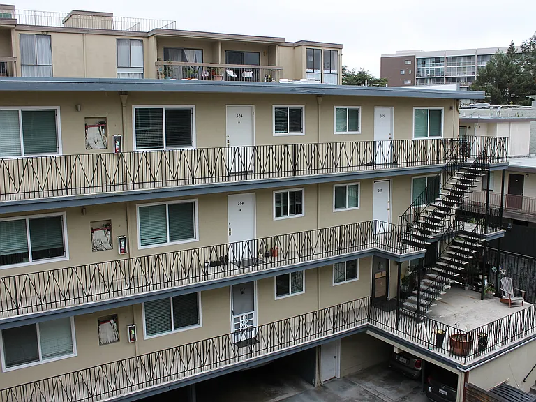 Charming multi-story apartment building with spacious balconies, excellent natural lighting, and outdoor sitting area. Charming multi-story apartment building with spacious balconies, excellent natural lighting, and outdoor sitting area.