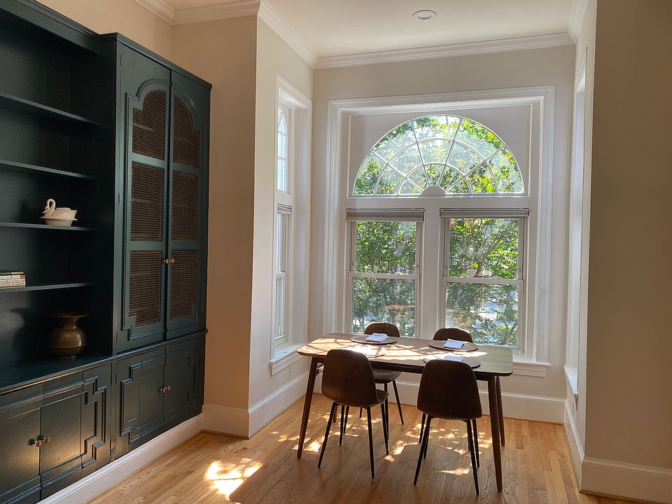 Dining table seats 4 in sunny alcove with large windows on 3 sides