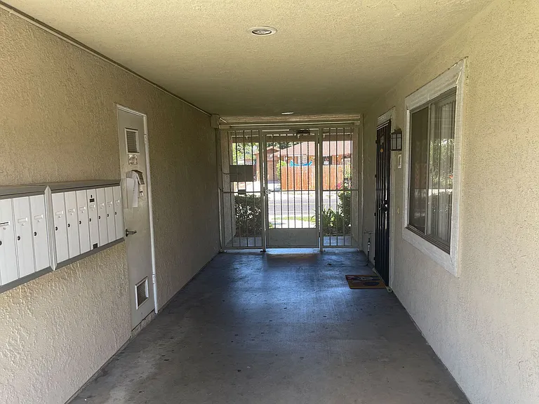 Entrance hallway with mailboxes and security door to front yard at Eucalyptus Apartments in Moreno Valley, California.