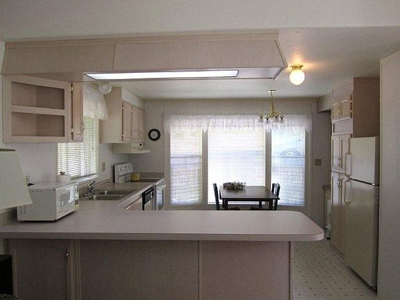 This was taken from the living area into the kitchen. You can see what a great size it is. The light is amazing and everything is so fresh and clean. Lots of counter top space for your cooking needs. There is room for more than one cook in this kitchen! Note that there is room for others to sit or dine at the counter.