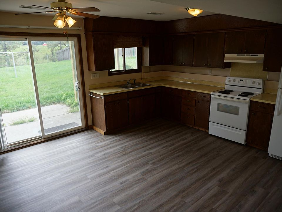 Large kitchen with a sliding glass door leading to a huge, fully-fenced back yard.