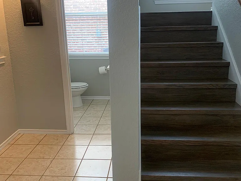 Hall to half bath and staircase to upstairs loft/workout area and bedrooms.
