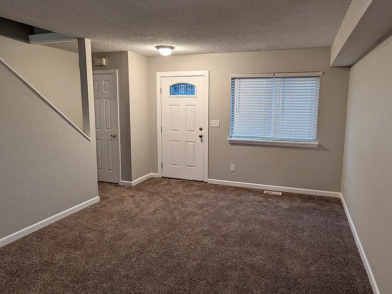 Main floor living room and front entrance door and coat closet.