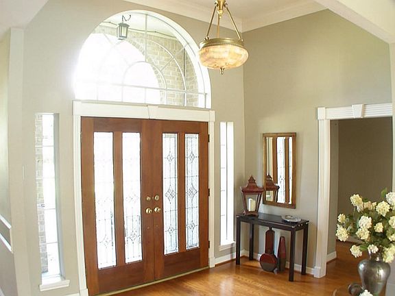 Smart looking entry hall with leaded glass doors and the wood floors set the tone for this jewel