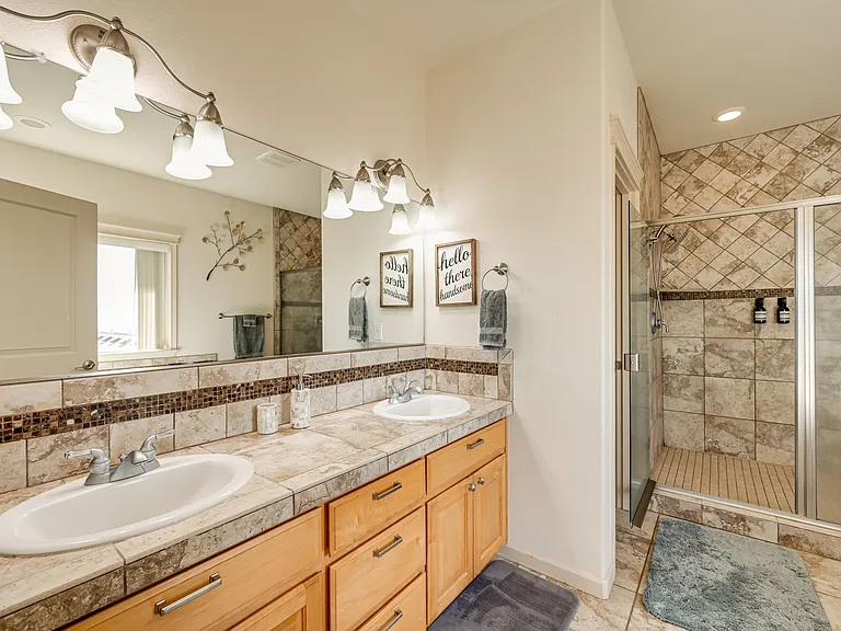 Featuring double sinks, separate water closet, double shower, and soaker tub