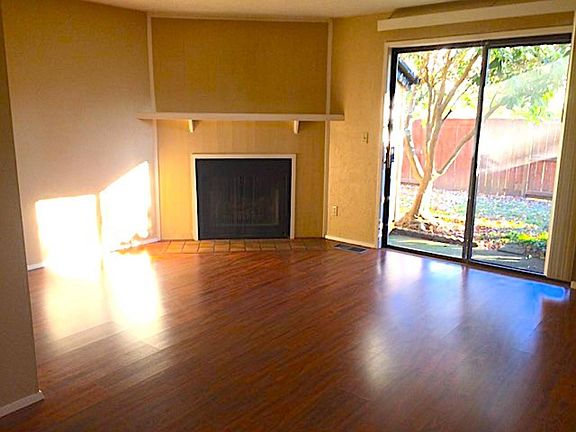 Large living/Dining room with fireplace. Sliding glass doors to patio and large locked storage area