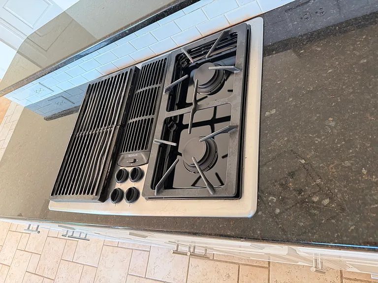 Versatile center island cooktop with griddle, grill and burners _ switch between searing, grilling and boiling for all your favorite meals.