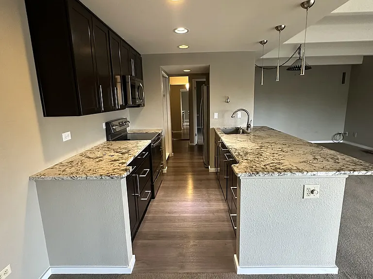 Kitchen from dining room corner with living room area to the right