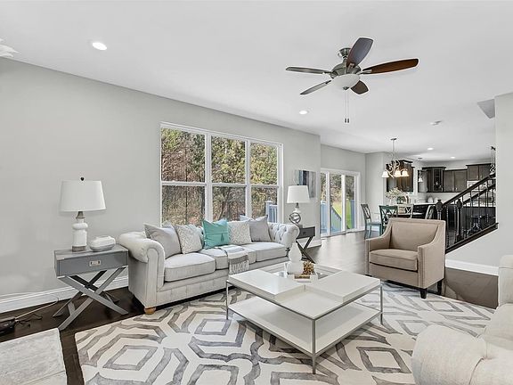 The Great room is open and has a spectacular view of the wooded tree line.  Recessed lighting, Fireplace with stone hearth, ceiling fan.  Hardwood floors span the main floor. Wide spindled stairway leads to large second story with another flex room.
