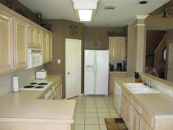Gourmet kitchen boasts ceramic tile flooring & backsplash, abundant 42" cabinetry, huge walk-in pantry, & large breakfast bar! Chef's delight!