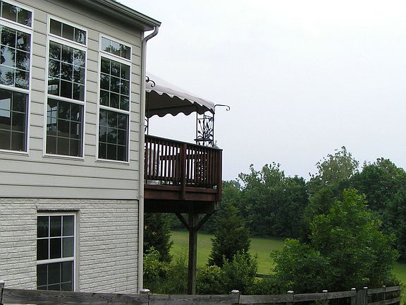 sunroom, deck, and large meadow with creek 