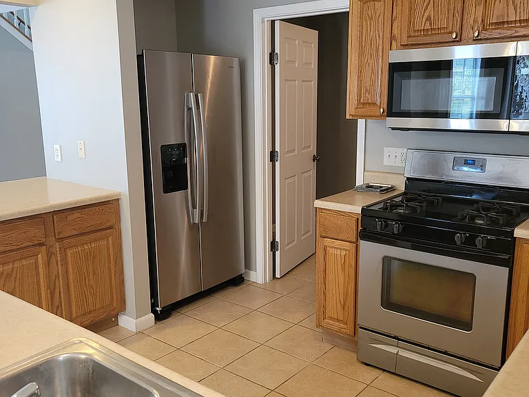 Kitchen with deluxe stainless gas stove, built in Microwave, and Side-by-side refrigerator with ice maker and water dispenser