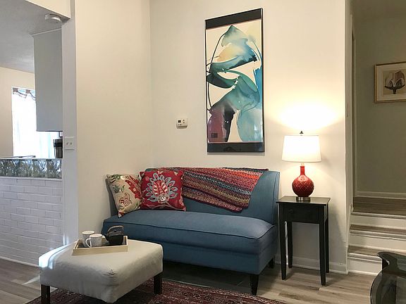 LR from entry door showing kitchen to left and 3 internal stairs to bath/bedroom(s) hallway.