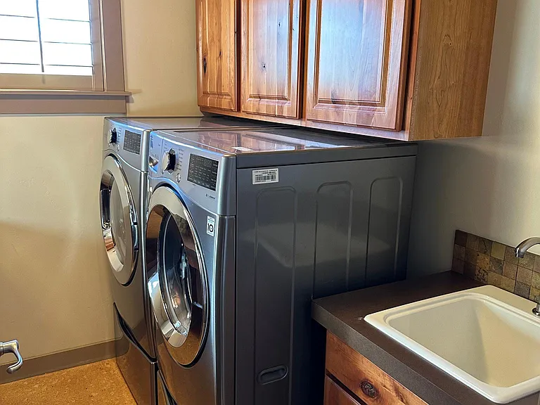 Upstairs laundry room includes front load washer and dryer. Utility sink