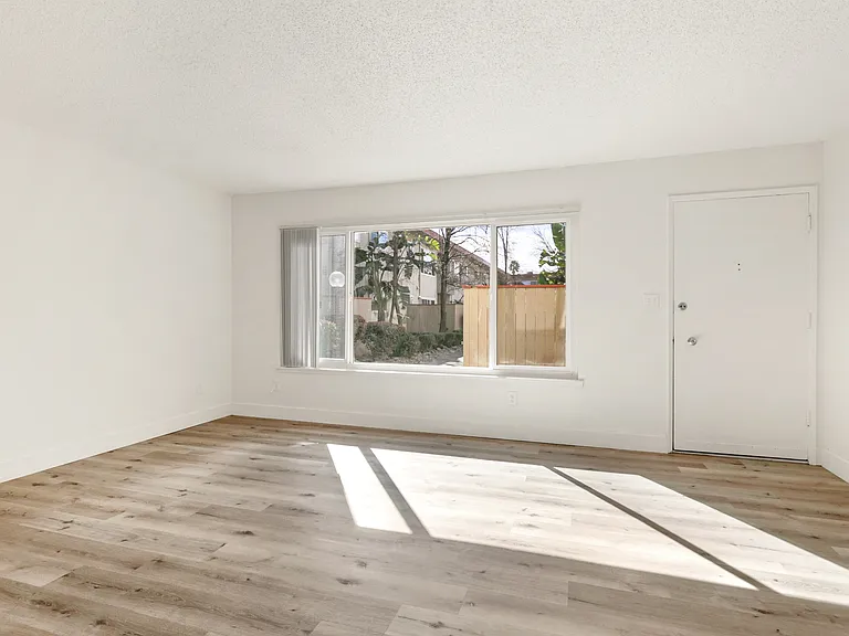 Living room with plenty of natural light, big windows.