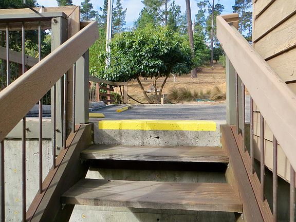 Stairs up to driveway, parking, and garage areas.