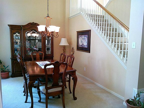 UPON ENTERING THE HOME, THE GUESTS SEE THIS BEAUTIFUL FORMAL DINING  ROOM WITH  TAUPE COLORED CARPET AND A  BEAUTIFUL CHANDELIER.