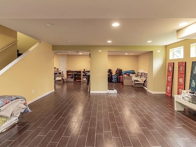 Professionally finished basement with ceramic tile and recessed lighting