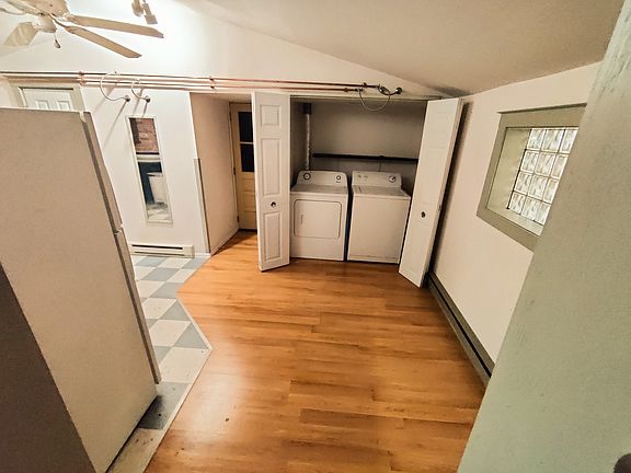 View into the dining and kitchen space. Doors to the washer and dryer are open.