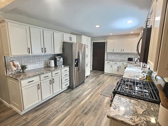 Spacious kitchen with granite countertops, large farm sink, gas stove and plenty of storage!