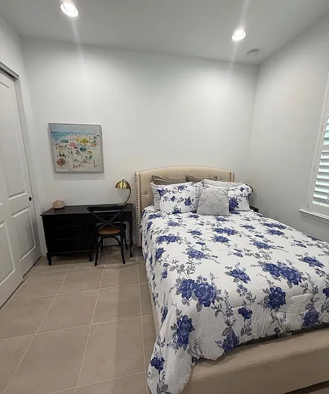 Bedroom 2 features a queen bed with both a sit down desk and a standing desk with a printer.