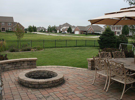 Brick paver patio with seating, fire pit & fenced-in backyard
