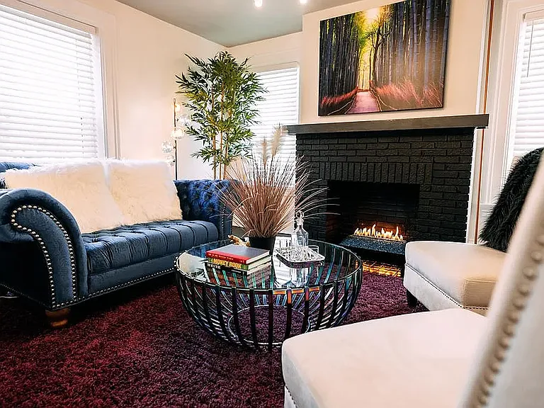 A TV is currently mounted above the fireplace, in place of the artwork shown, and will remain for tenant use.