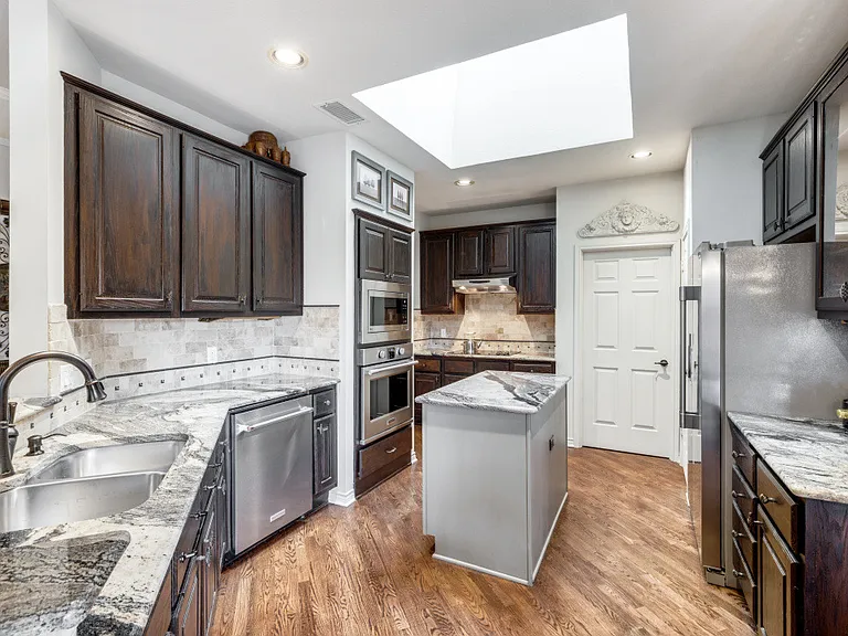 Wood floor, center island, skylight, stainless steel appliances, all bring joy to the chefs of the family.