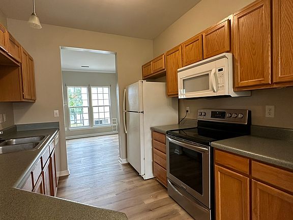 Kitchen with electric range, microwave, refrigerator and dishwasher included.