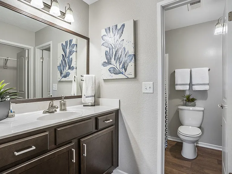 Large mirror vanities and plentiful storage in bathrooms.