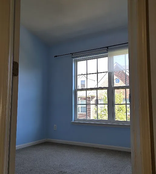 The guest room features a large window that fills the space with natural light, creating a bright and inviting atmosphere.