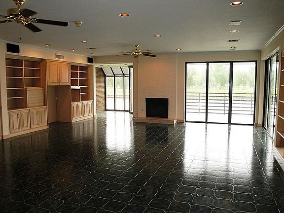 Spacious living room has been customized for large gatherings including built in entertainment system and fireplace flanked by views  to Clear Lake.