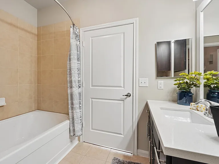 Bath with dark cabinetry, white quartz countertops, and hard surface flooring