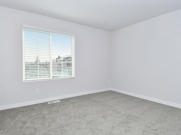 The master bedroom is spacious with a large window.