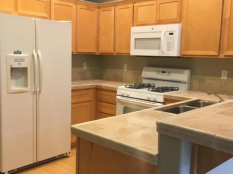 Kitchen with gas stove, plus built-in microwave and bamboo flooring.