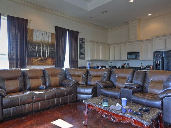 Large open living area opens to kitchen. Floor to ceiling windows surround the area.