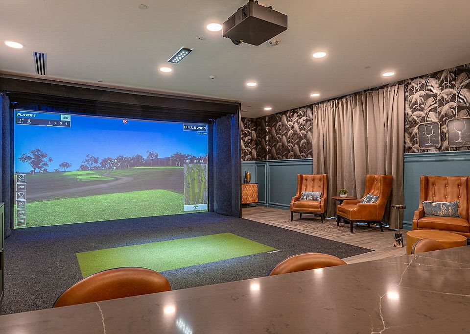 Recreation room with golf simulator and dry bar.