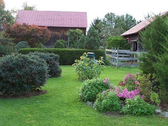 main barn in back behind English garden; small animal barn on right