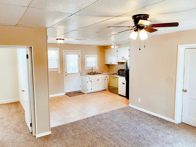 Living room, dining room and kitchen. Bedroom entrance on door to the left, laundry room on door to the right. Back door leading to private backyard seen in back-middle