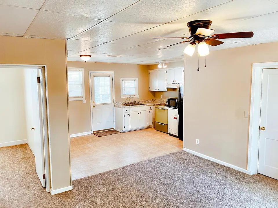 Living room, dining room and kitchen. Bedroom entrance on door to the left, laundry room on door to the right. Back door leading to private backyard seen in back-middle