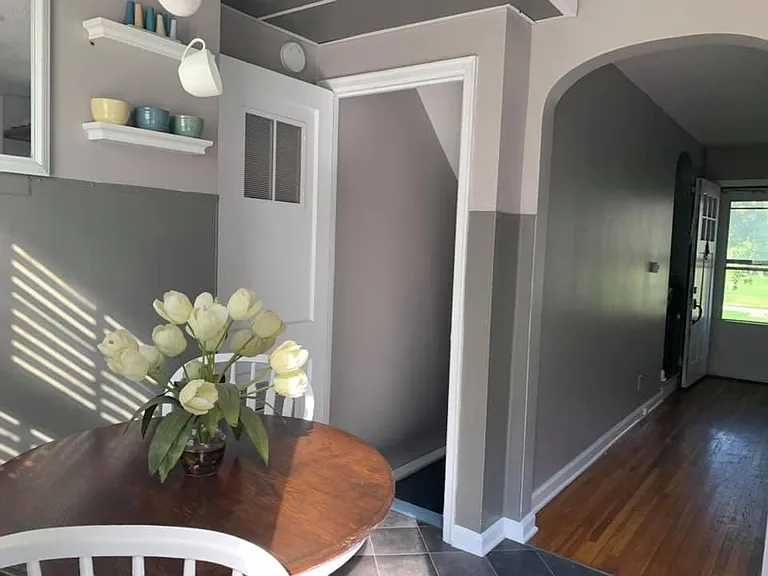 Kitchen and dining area with door way to basement and view to the living room and front door